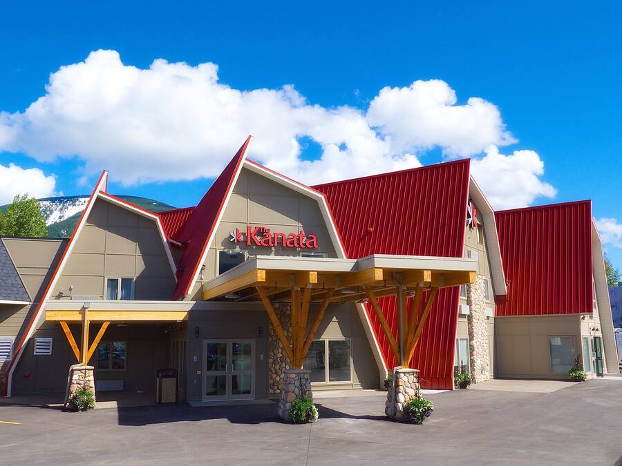 Un hotel con un diseño arquitectónico único, que presenta un techo rojo y un cartel que dice "The Kanata".