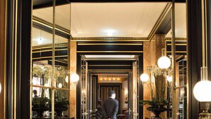 A grand hallway with a polished marble floor, ornate mirrors, and classical decor. - La Reserve Paris Hotel and Spa (Paris)