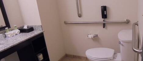 Een standaard hotelbadkamer met toilet, bidet, handdroger en een handdoekrek.