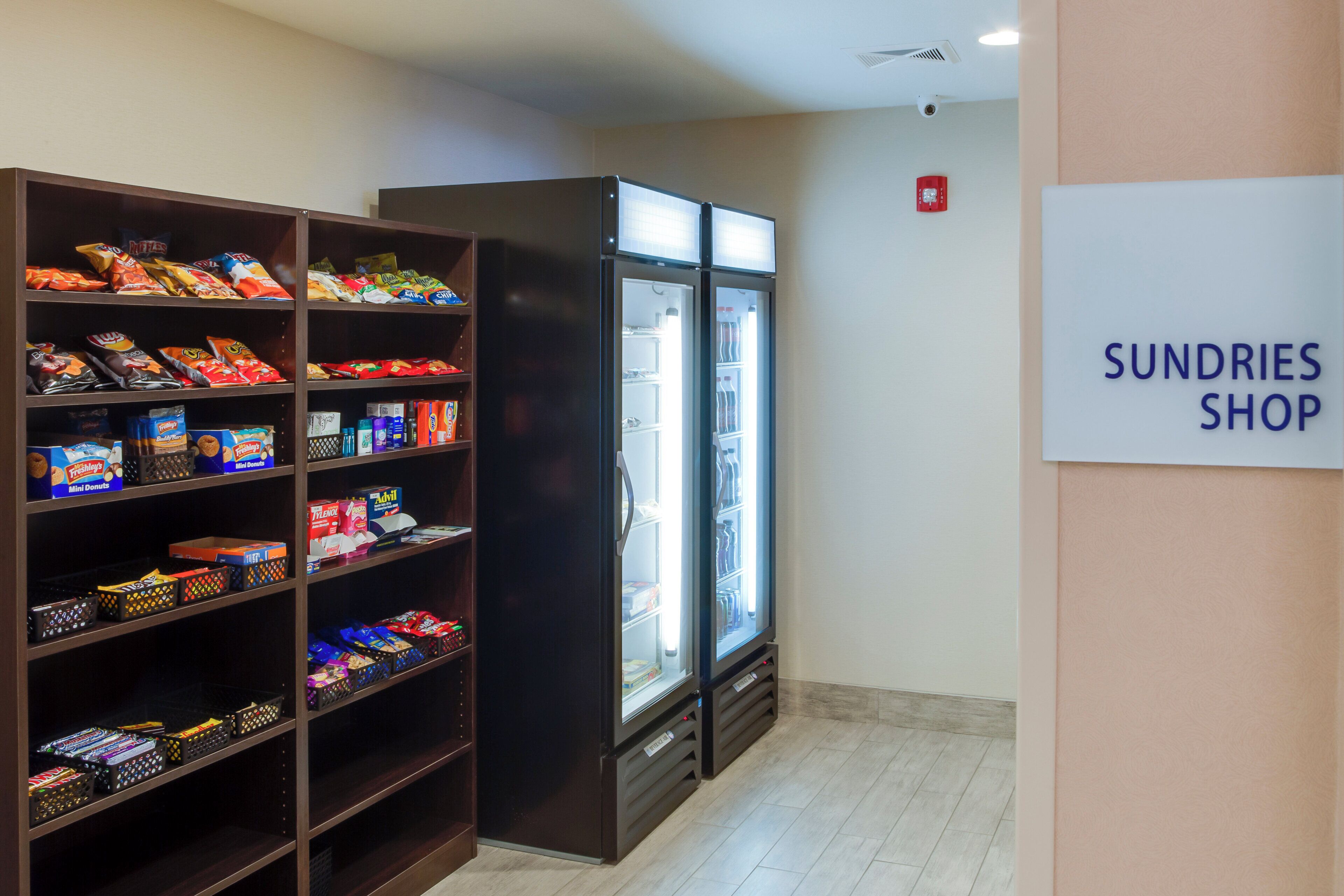 Una tienda de artículos varios con estantes llenos de aperitivos y un refrigerador.