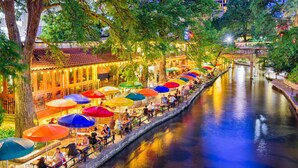 A riverside dining area with outdoor seating and umbrellas. - Holiday Inn Express & Suites San Antonio - Brooks City Base by IHG (San Antonio)