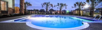 Una piscina al aire libre, sillones reclinables de piscina