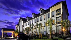 A multi-story hotel with a modern architectural design, featuring a flat roof and large windows.