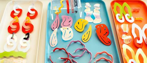 Trays of colorful paper cutouts and earrings.