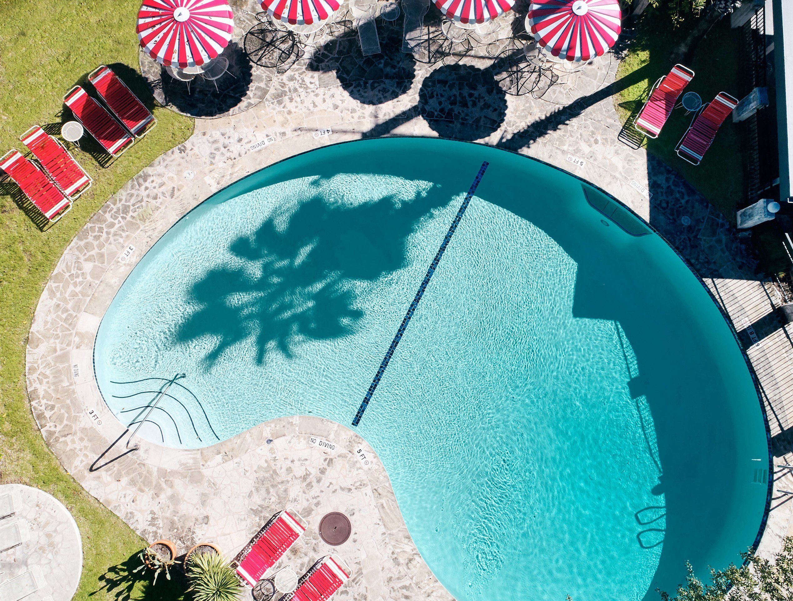 Una piscina al aire libre, sillones reclinables de piscina