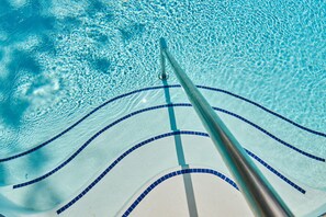 A swimming pool with clear blue water and a diving board.
