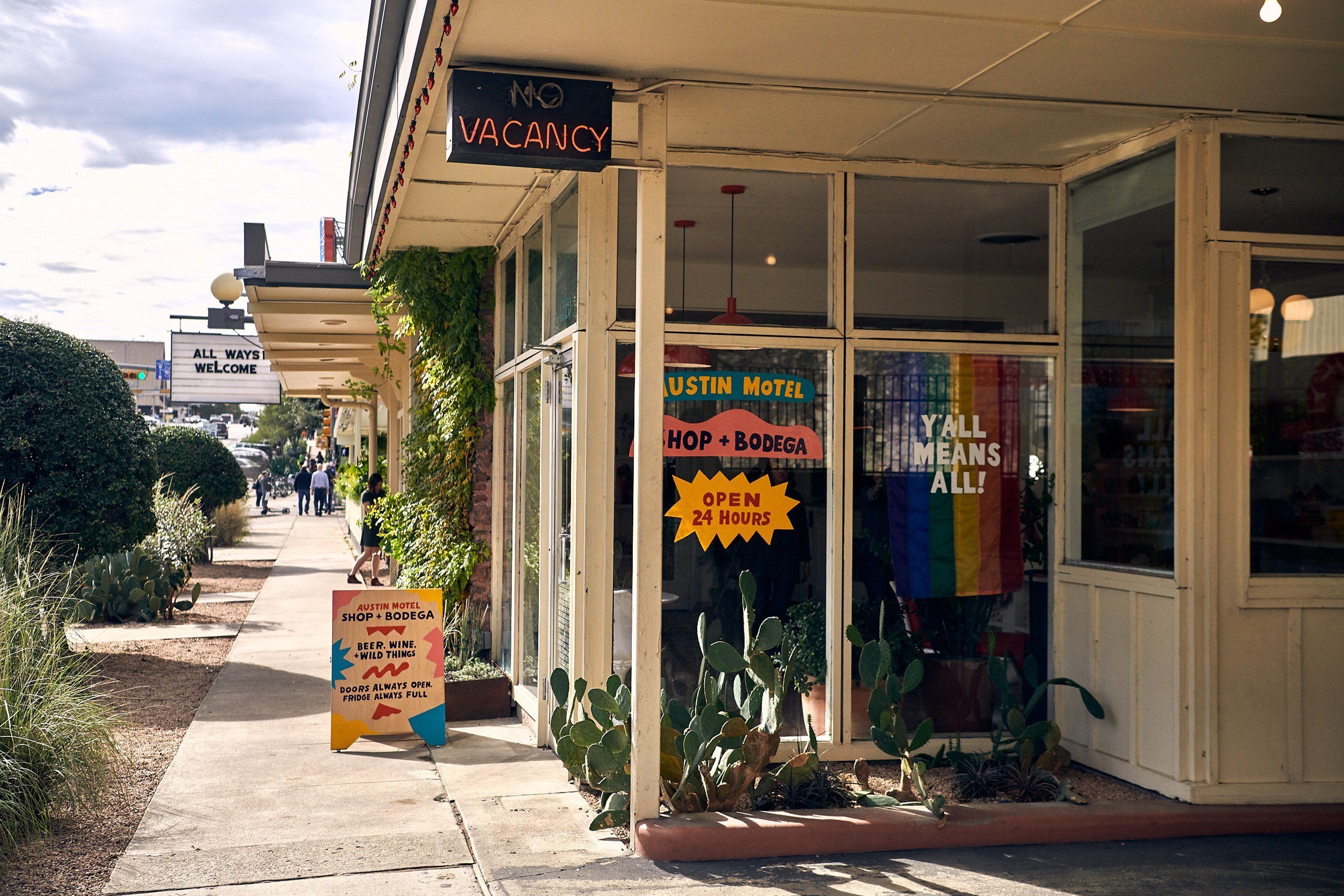 A storefront with a 'No Vacancy' sign, a '24 Hours Open' sign, and a 'Austin Motel' sign.