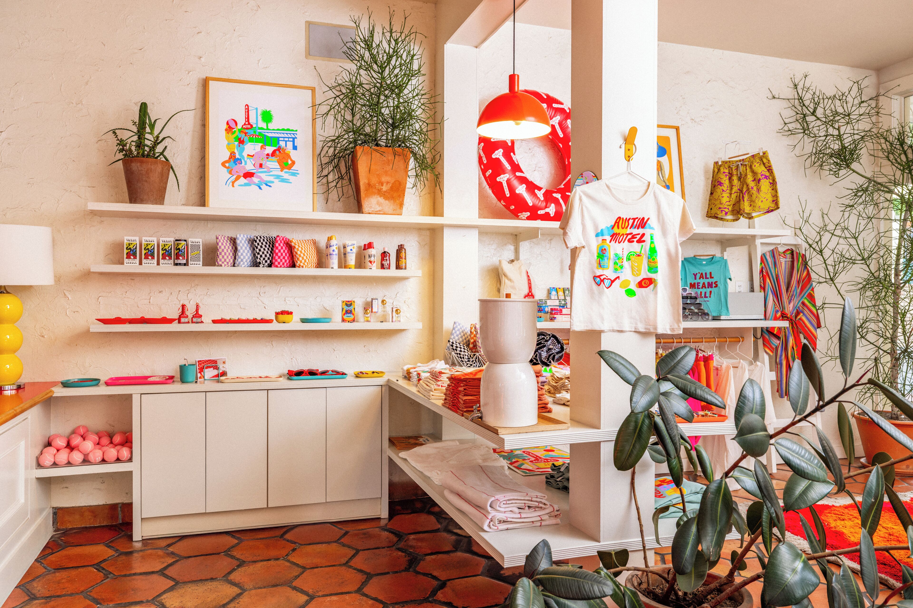 A room with a tiled floor, shelves with various items, a plant, and a hanging lamp.