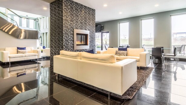 Un salon moderne avec une cheminée, des canapés blancs et un escalier.