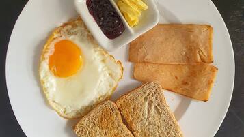 A plate with a fried egg, two slices of toast, and a small dish containing jam and butter.