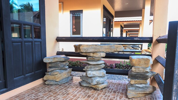 A stone staircase leading to a covered area with a black railing. - Needa Rock Resort (Khanom)