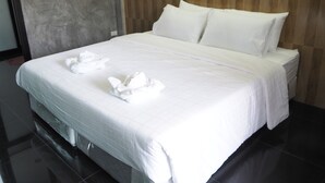 A large bed with white linens, a wooden headboard, and two pillows. - Needa Rock Resort (Khanom)