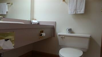 A bathroom with a toilet, a sink, and a towel rack.