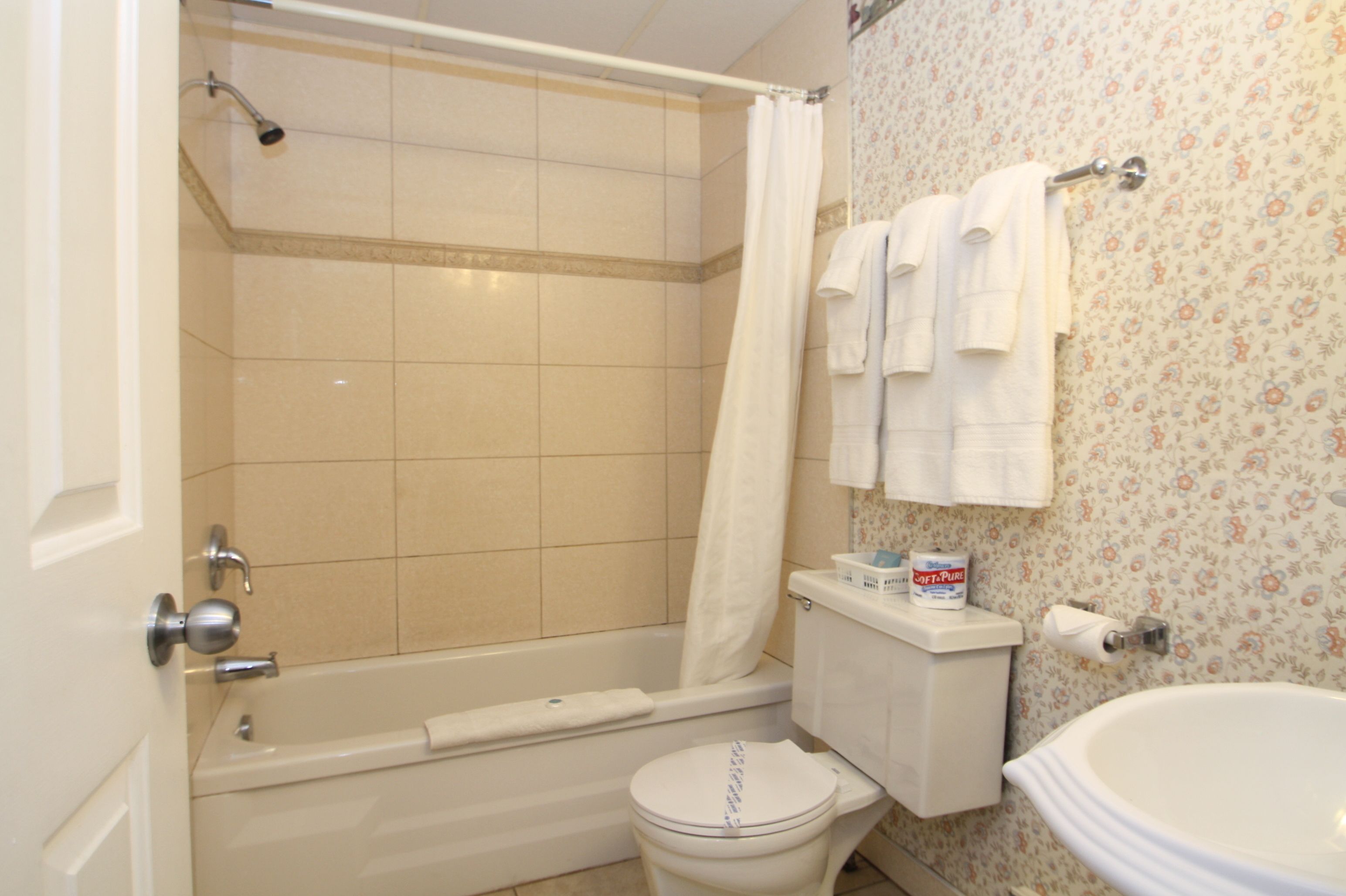A bathroom with a bathtub, toilet, and sink.