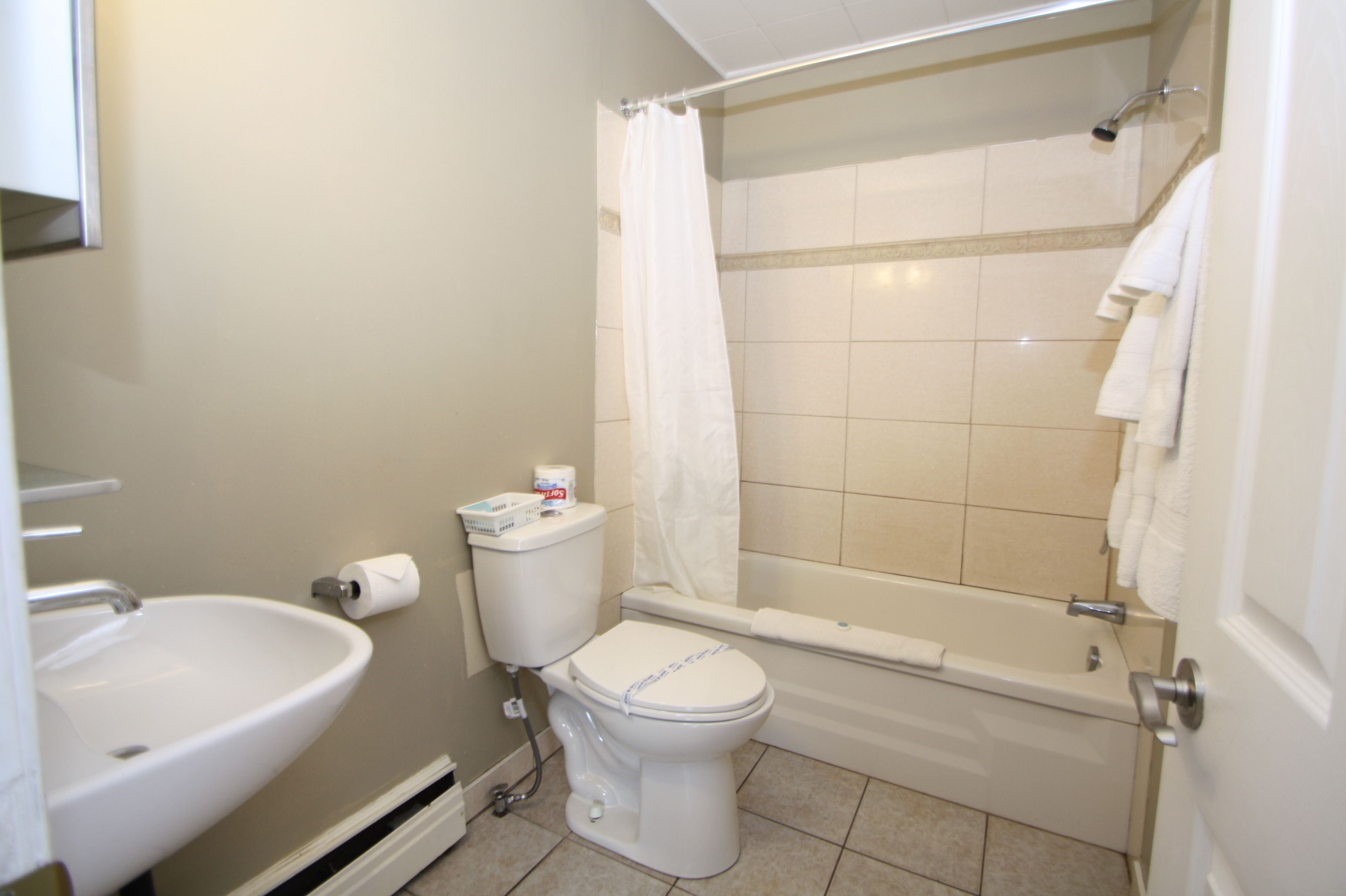 A bathroom with a toilet, sink, and bathtub.