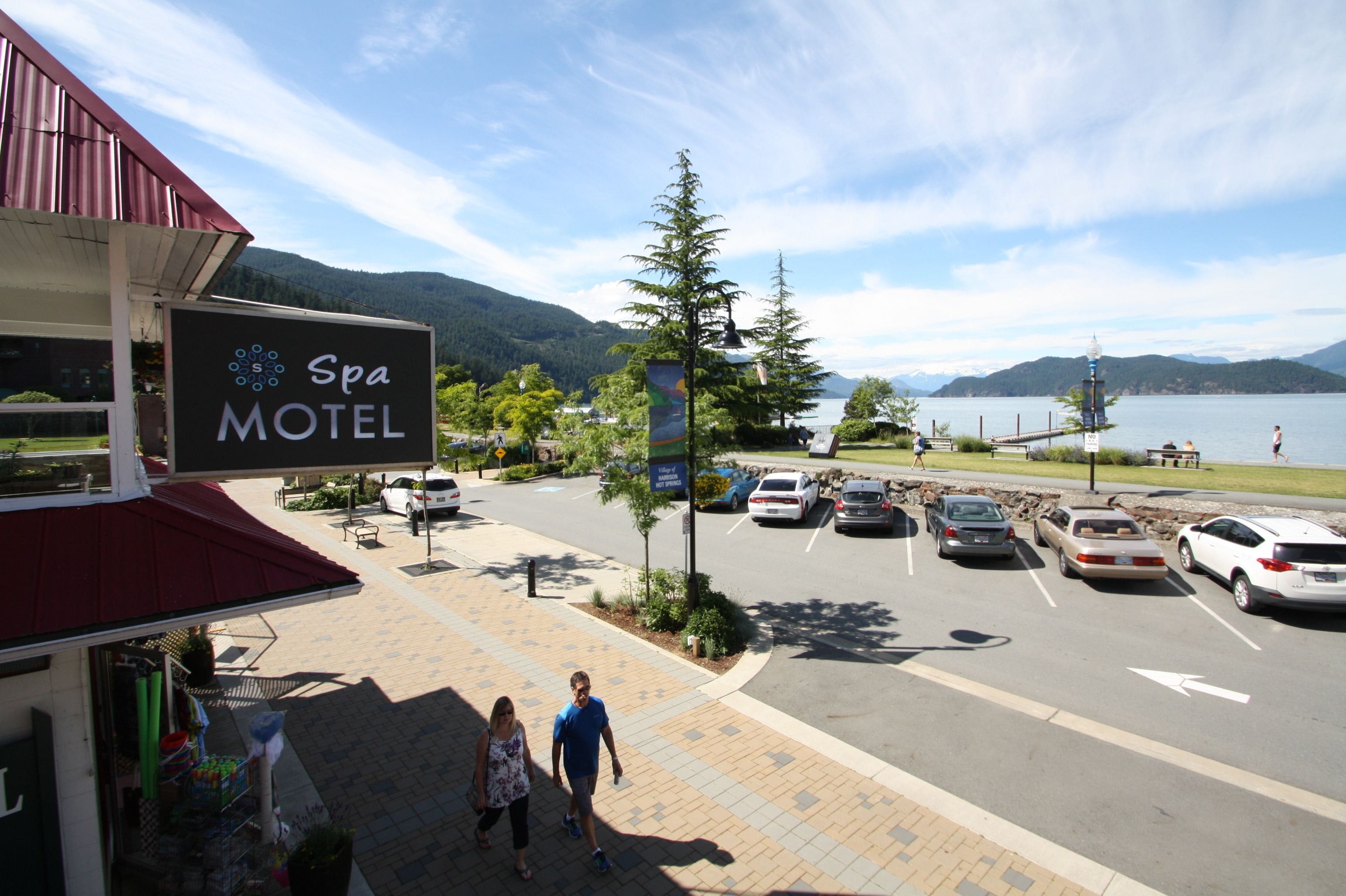 Een motel met een bord waarop 'Spa Motel' staat en een parkeerplaats met auto's.