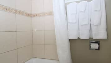 Un baño con bañera, inodoro y ventana.