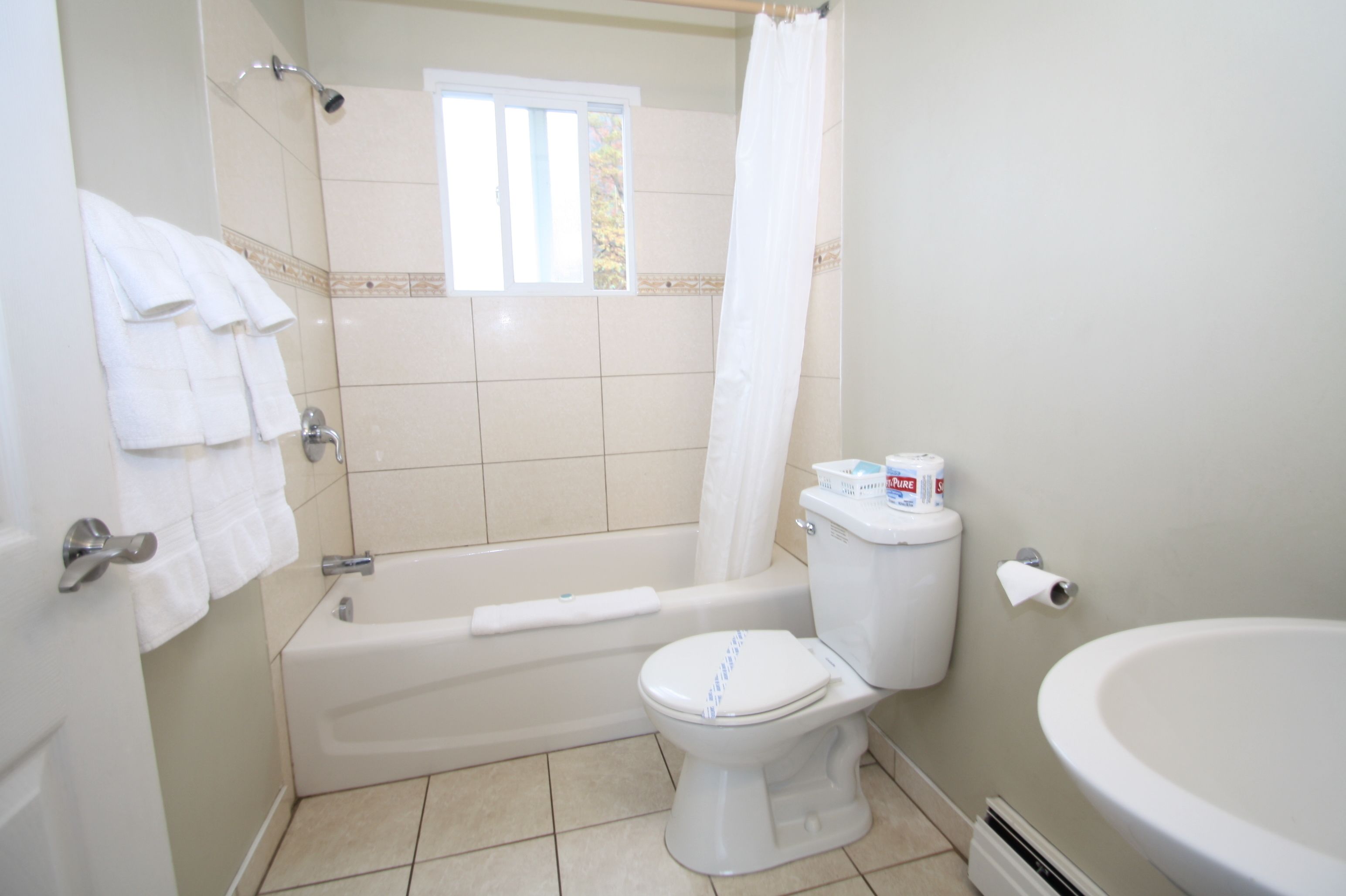 Un baño con bañera, inodoro y lavamanos.