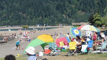 Guests can enjoy a serene beach experience with umbrellas providing shade and lawn chairs for seating.