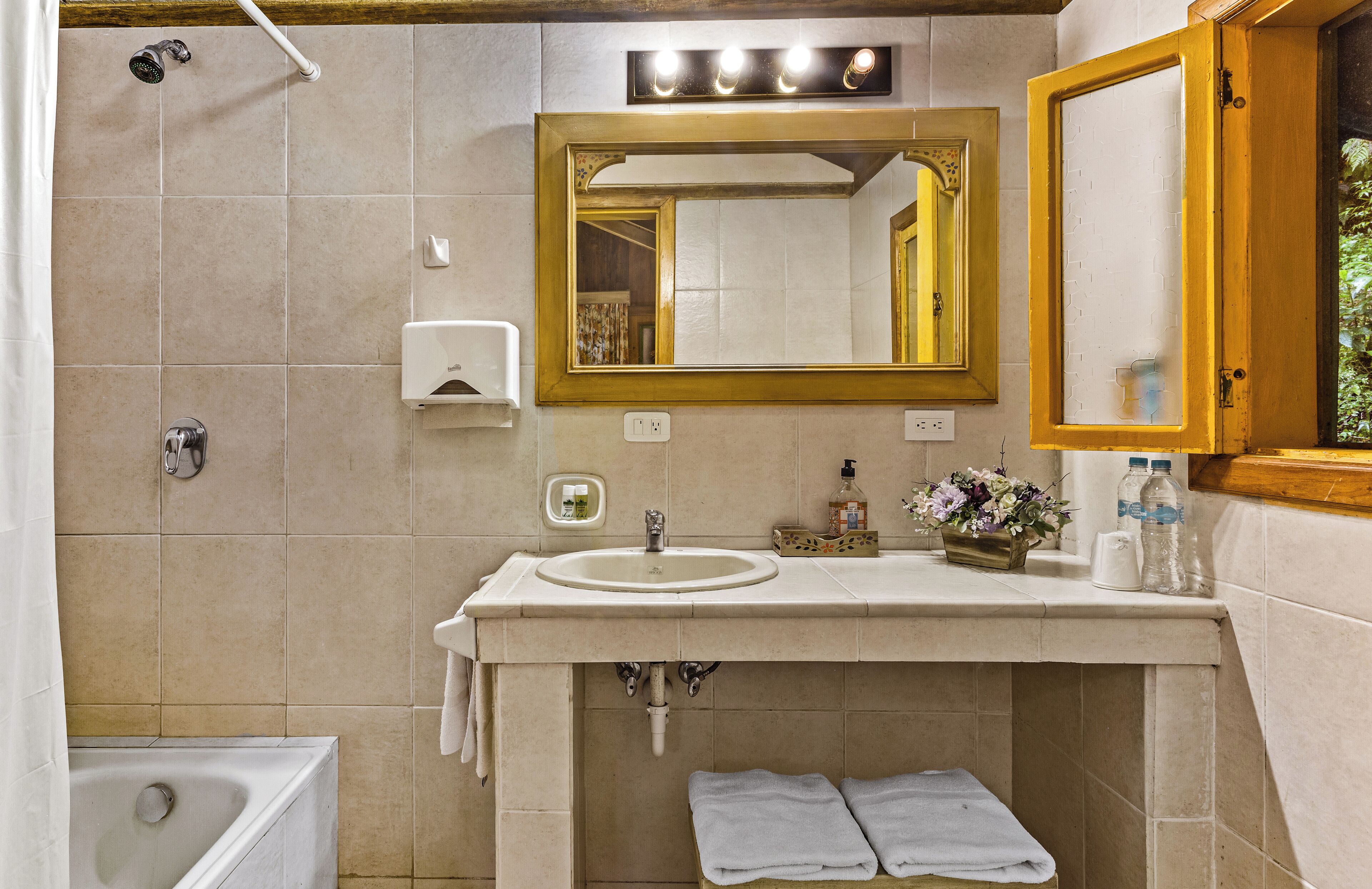 A bathroom with a sink, mirror, shower, and bathtub.