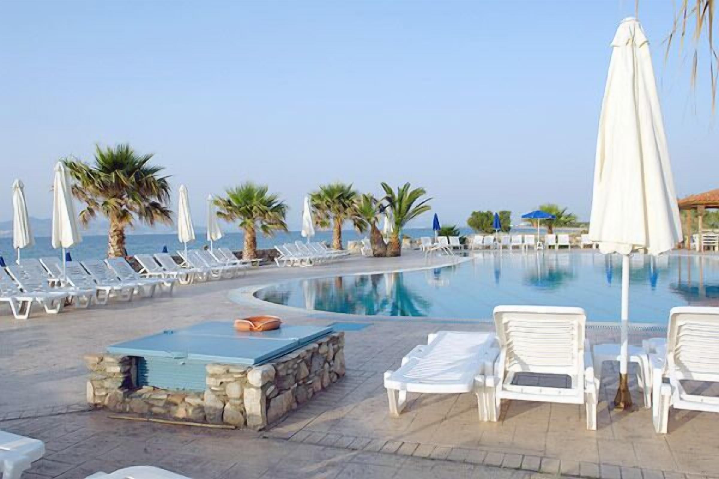 seasonal outdoor pool, an infinity pool, pool umbrellas, pool loungers