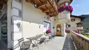 A hotel patio with outdoor seating and a sign reading "Hotel Crosta." - Hotel Crosal (Livigno)