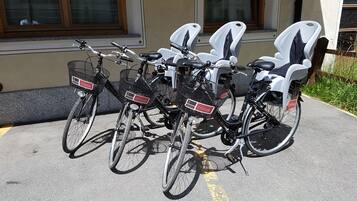 A row of bicycles with attached seats parked in a designated area.