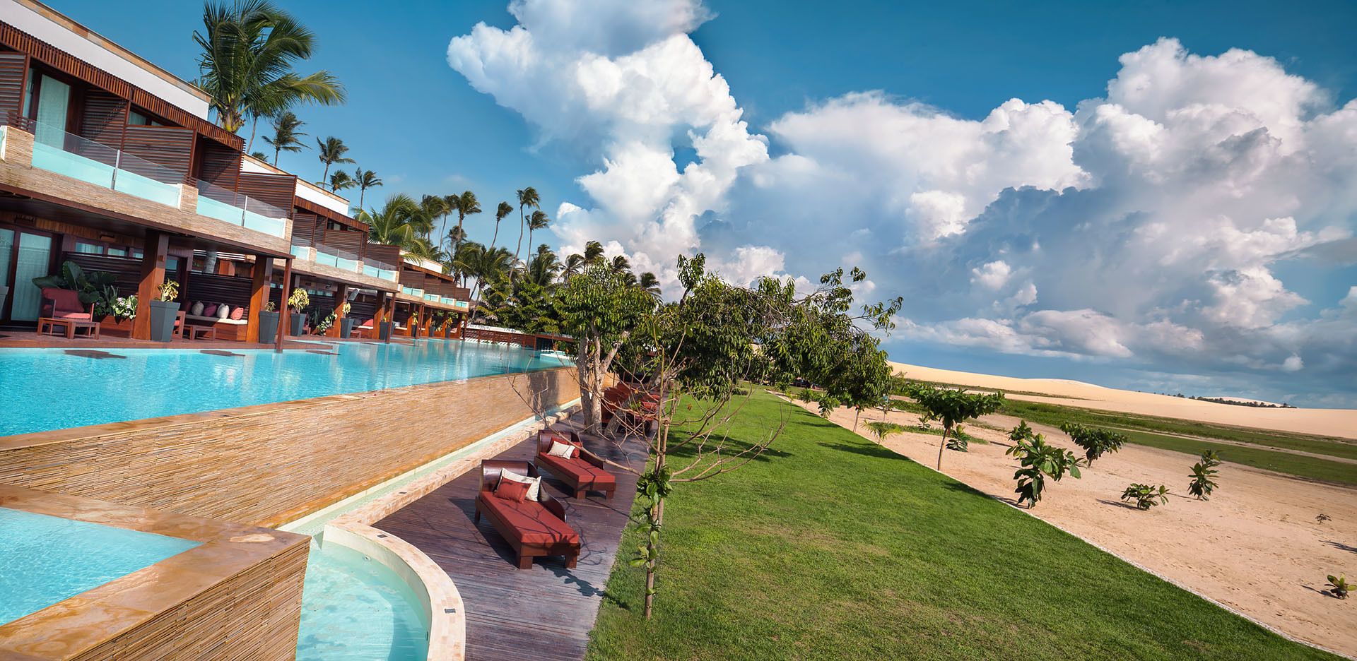 A resort with a swimming pool, lounge area, and desert landscape.