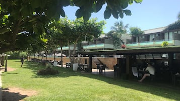 Un patio con mobiliario exterior, piscina y un edificio de diseño moderno.