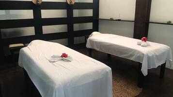 Relax in a serene space with two massage tables, a Buddha statue, and a cozy rug.