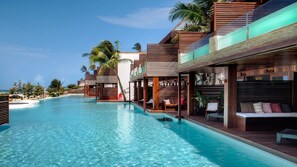Un resort con una gran piscina, terrazas de madera y varios niveles de habitaciones.