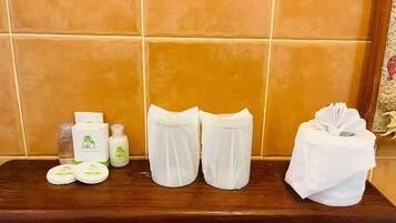 A bathroom shelf with toiletries including soap, lotion, and towels.