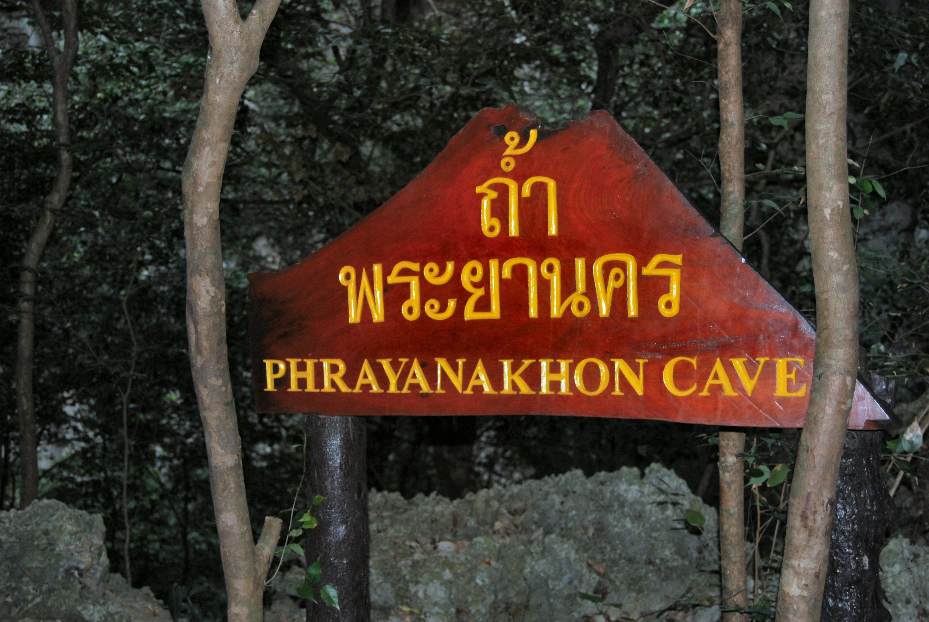 Placa de entrada de caverna com escrita tailandesa.