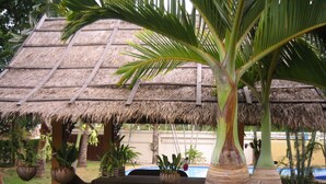 A thatched-roof structure with outdoor seating and potted plants. - Long Beach Inn (Sam Roi Yot)