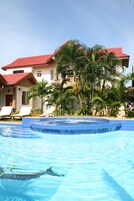 Una piscina al aire libre, sombrillas, sillones reclinables de piscina