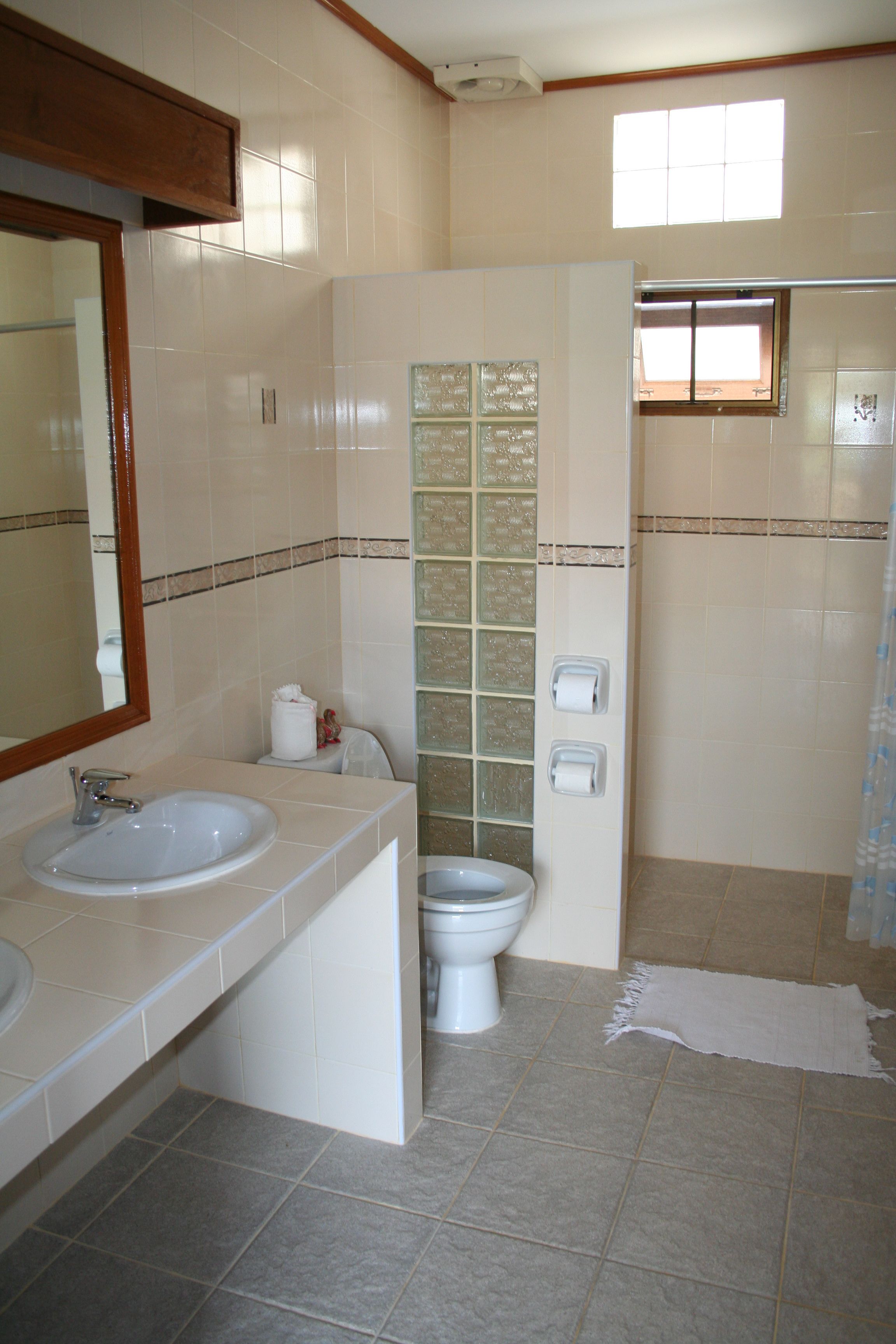 A bathroom with two sinks, a toilet, and a shower.