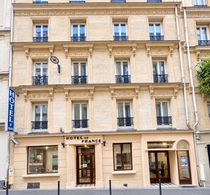 A multi-story hotel with a classic facade, featuring a prominent entrance with a glass door and a sign reading 'HOTEL DE FRANCE'. - Hotel de France (Paris)