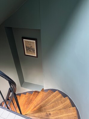 A staircase with a wooden handrail and a framed picture on the wall. - Hotel de France (Paris)