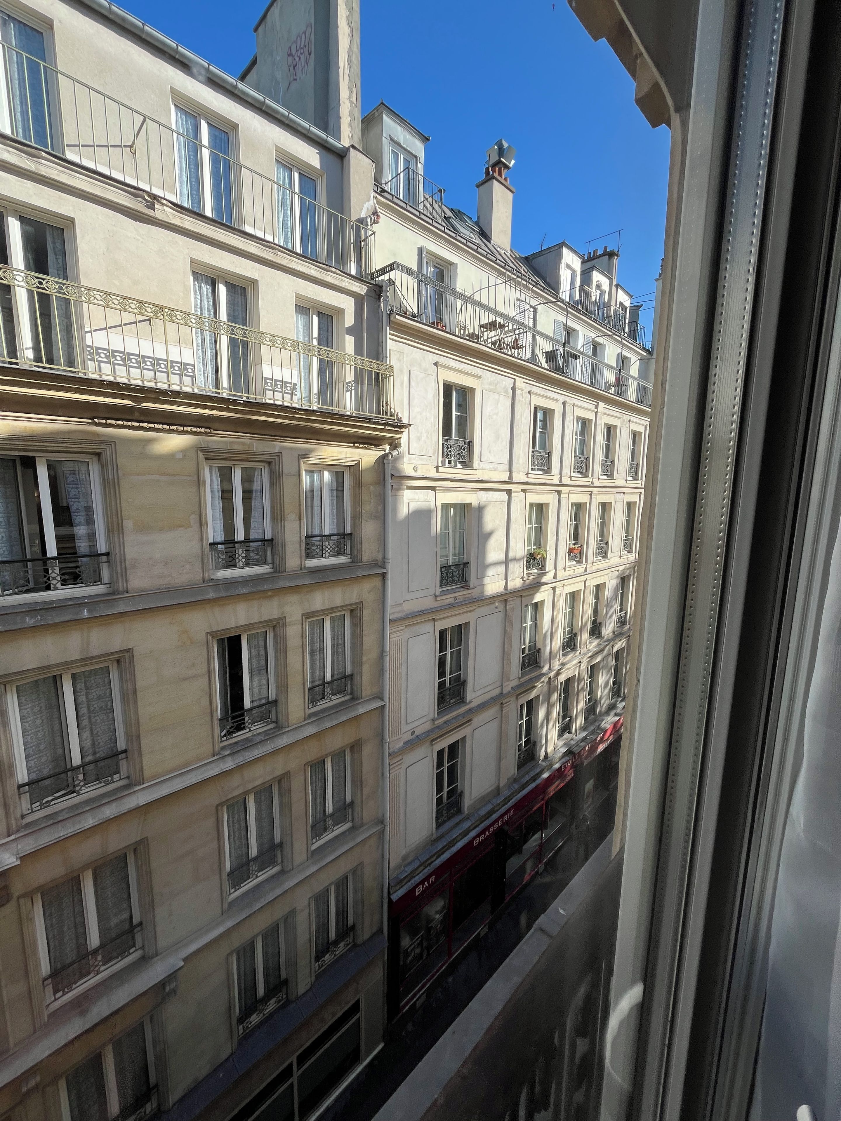 Un immeuble à plusieurs étages doté de balcons, de grandes fenêtres et d’une devanture visible.