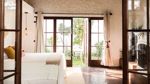 Una habitación con cama, ventana con cortinas y vistas al exterior.