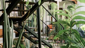 Una escalera con barandales de metal rodeada de abundante vegetación y plantas.
