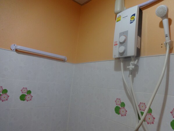 A bathroom with a white shower enclosure, a handheld showerhead, and a wall-mounted control panel. - Bird Bungalow (Ko Pha-ngan)
