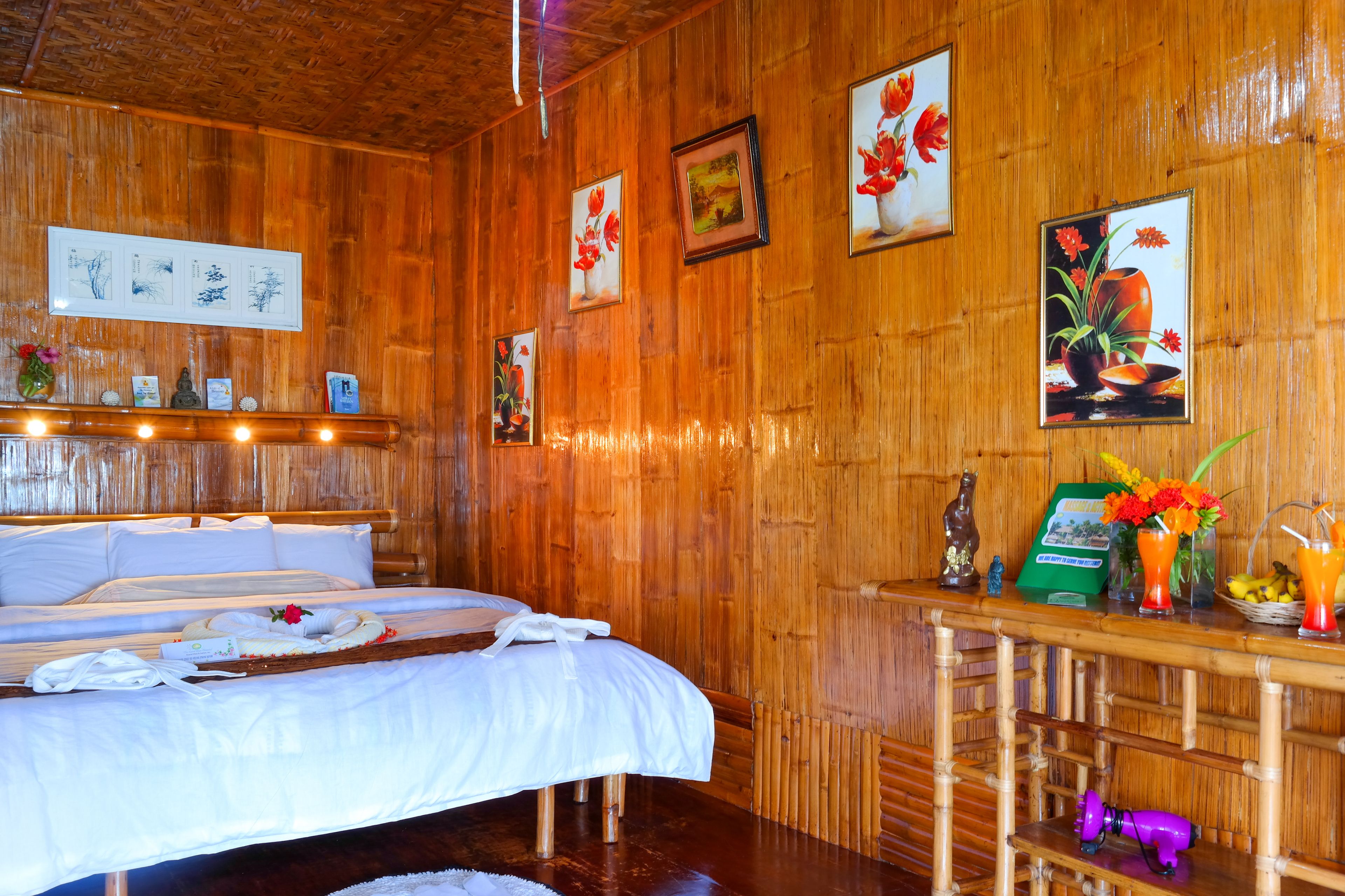 Una habitación de madera con una cama, estantes de madera y cuadros en las paredes.