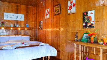 Una habitación de madera con una cama, estantes de madera y cuadros en las paredes.