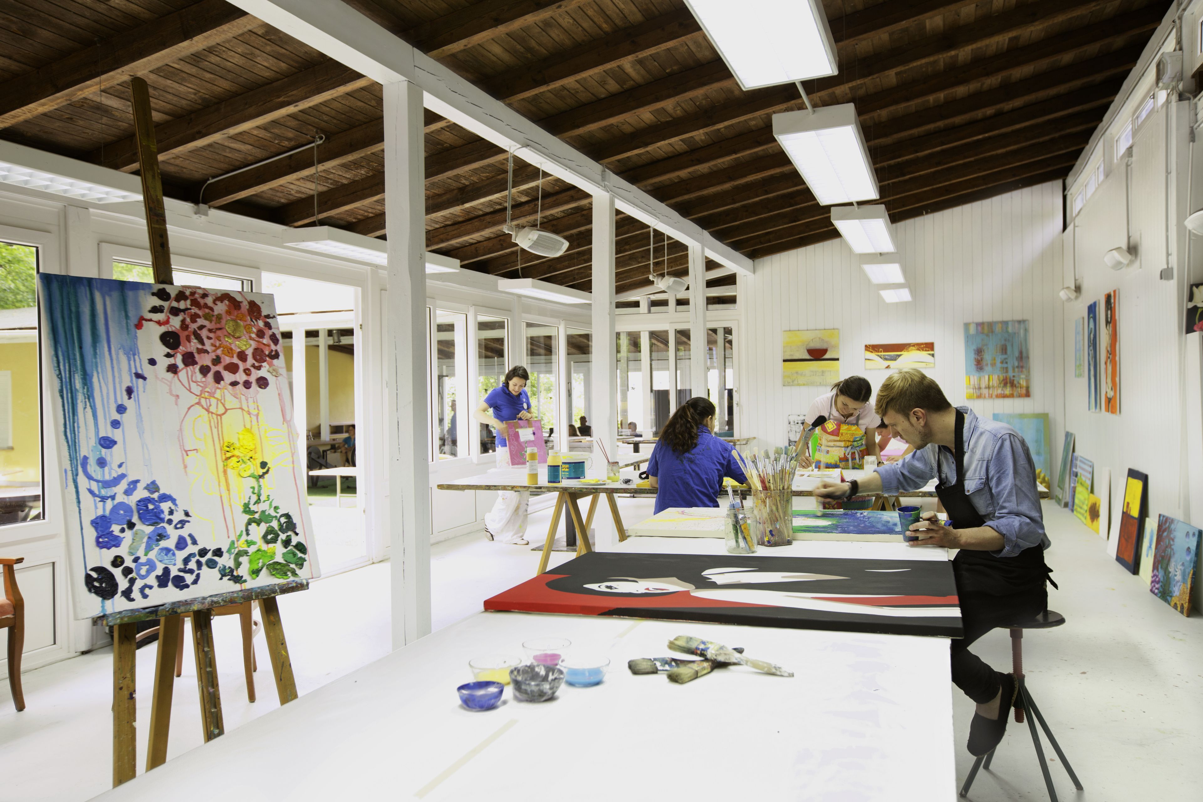 An art studio with easels, canvases, and art supplies.