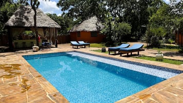 Alberca al aire libre y camastros