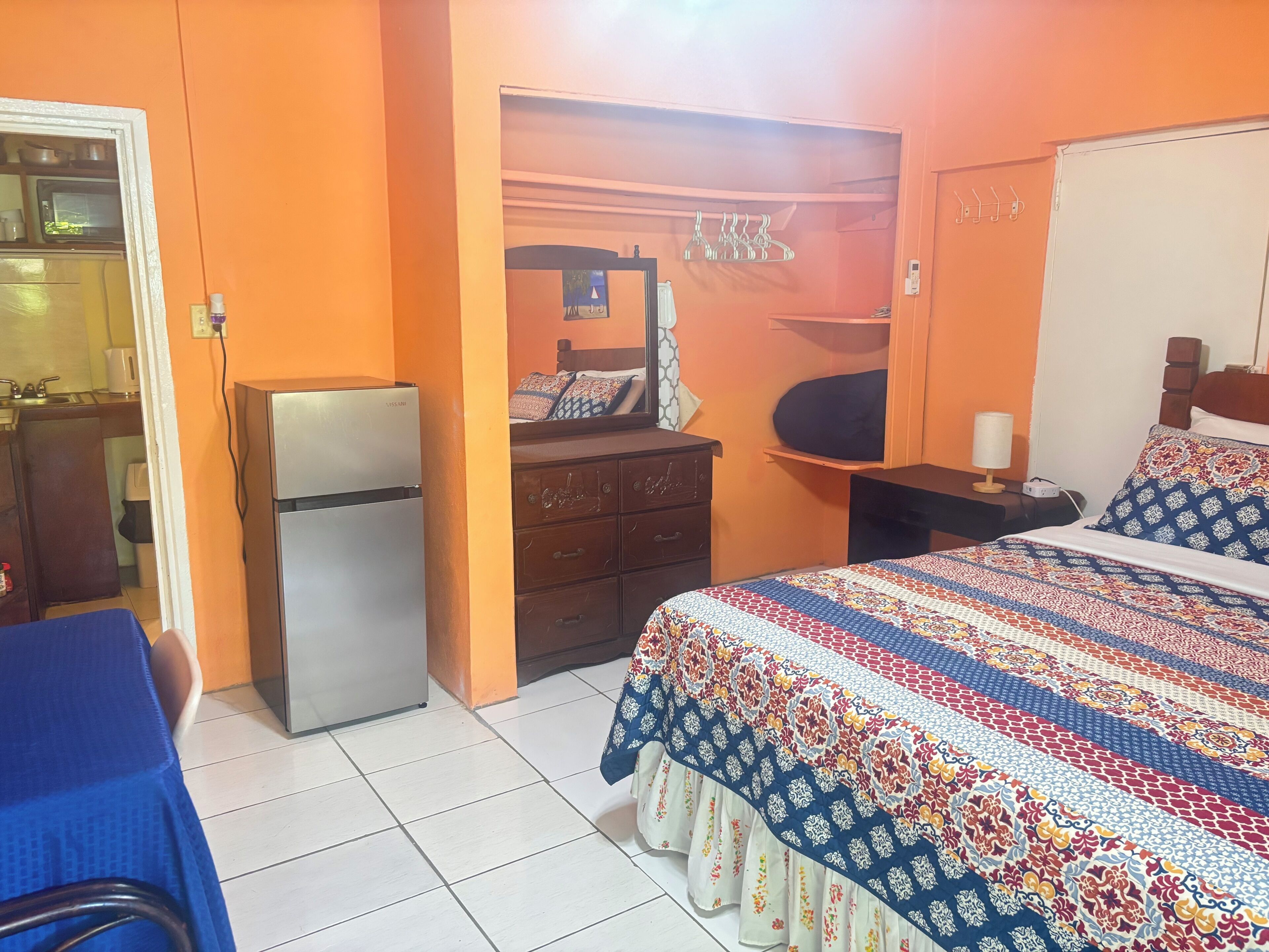 Une chambre d’hôtel équipée d’un lit, d’une commode, d’un bureau, d’un four à micro-ondes et d’un réfrigérateur.