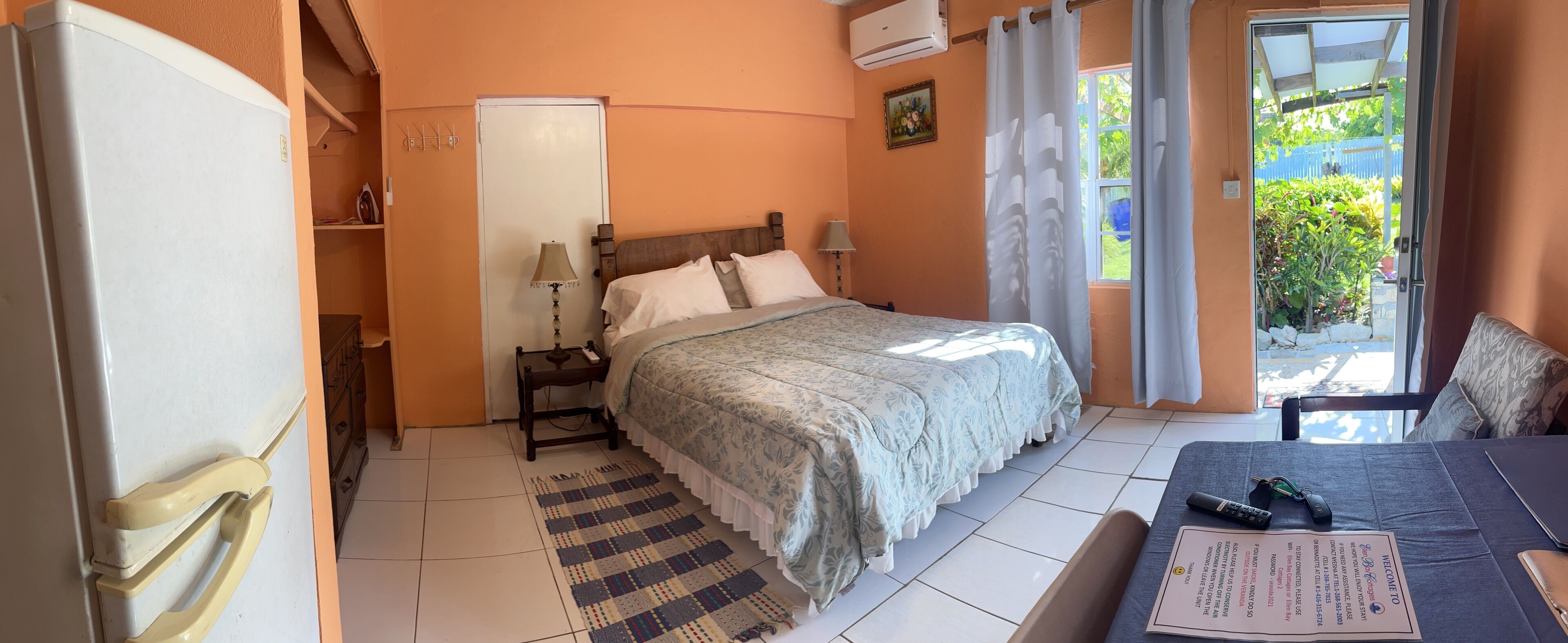 Una habitación de hotel con una cama, un escritorio con una silla, una mesita con un menú y una ventana con cortinas.