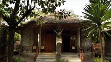 A stone building with a wooden door and a staircase leading to the entrance.
