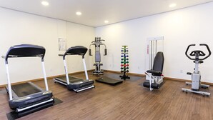 A gym with treadmills, a weight machine, and a rowing machine. - Hotel Express Rodoviária (Porto Alegre)